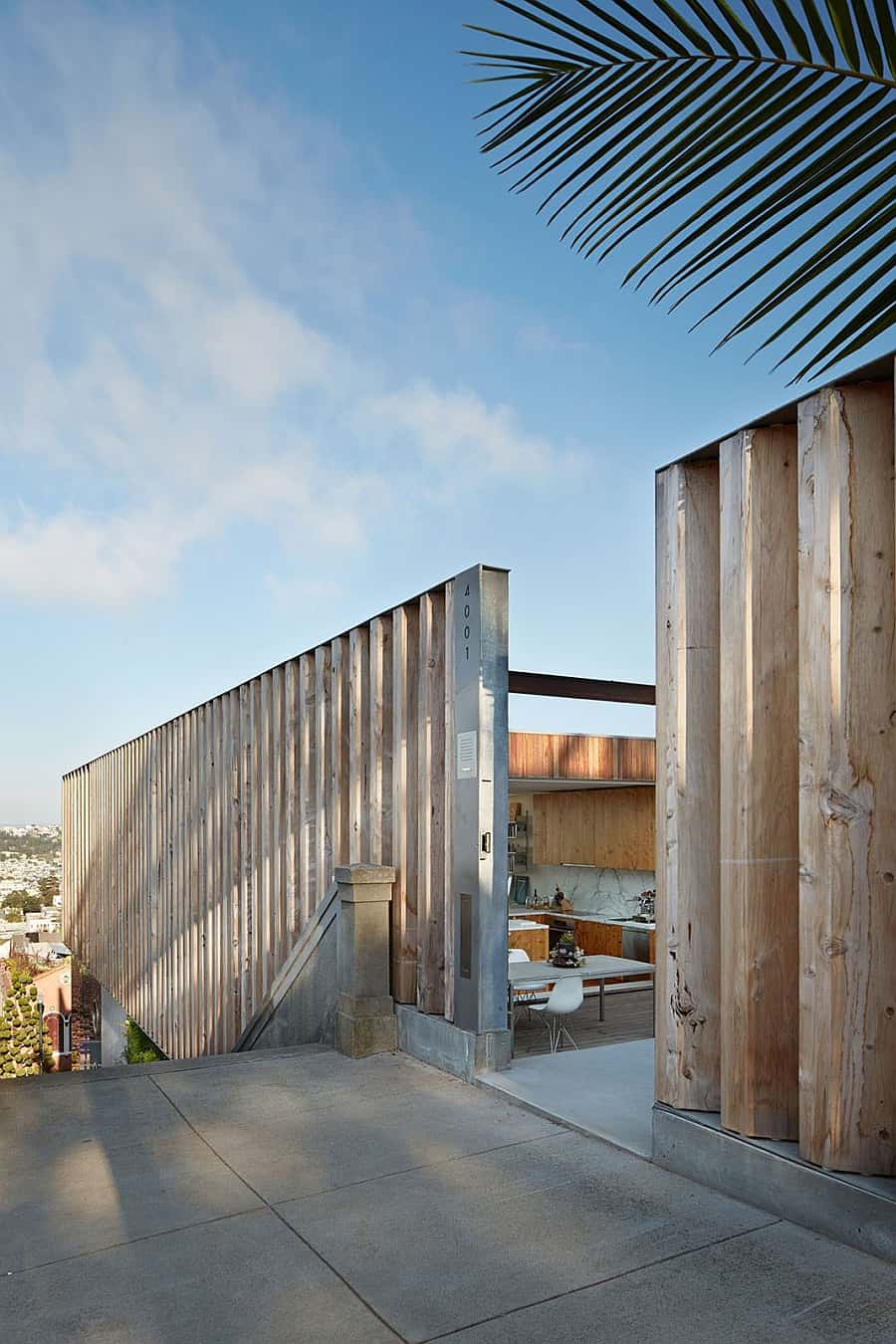 Terrace dining space and kitchen concealed by the giant solid wood louvers