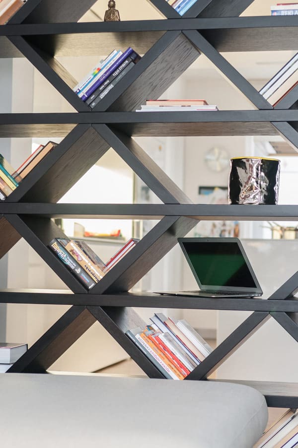 A cool bookshelf that divides the kitchen and living area