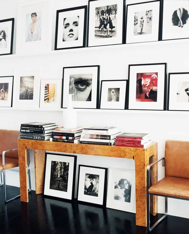 Modern photography gallery wall with modern burl console table and leather and chrome armchairs.